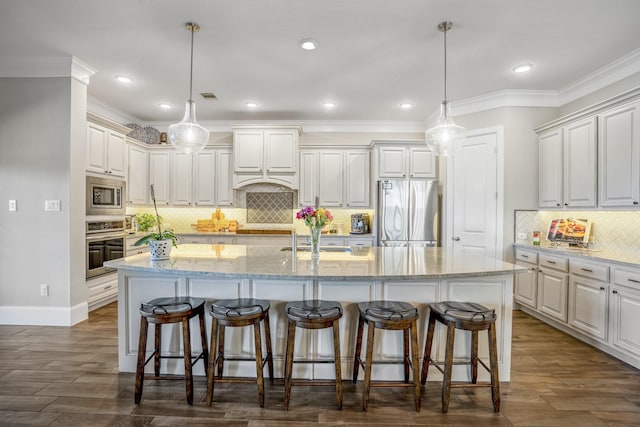 kitchen featuring stainless steel appliances, light stone counters, a kitchen island with sink, and pendant lighting