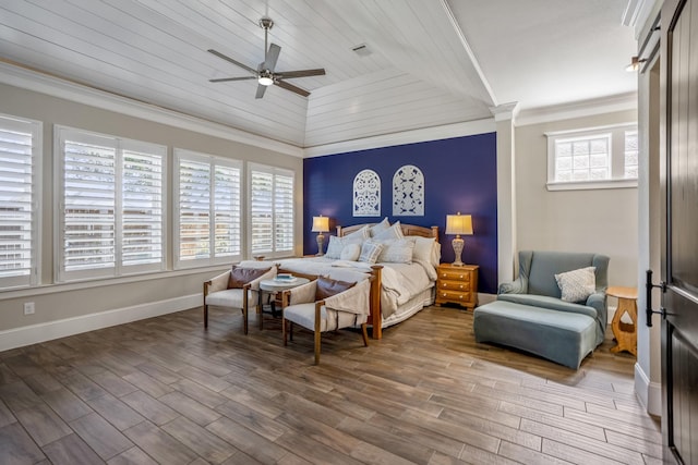 bedroom featuring baseboards, a ceiling fan, lofted ceiling, wood finished floors, and crown molding