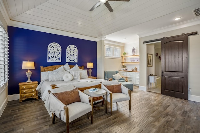 bedroom with dark wood-style floors, a barn door, and crown molding