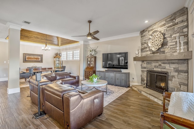 living room featuring crown molding, visible vents, a fireplace, and wood finished floors