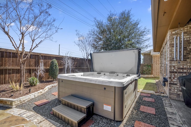 view of patio with fence and a hot tub