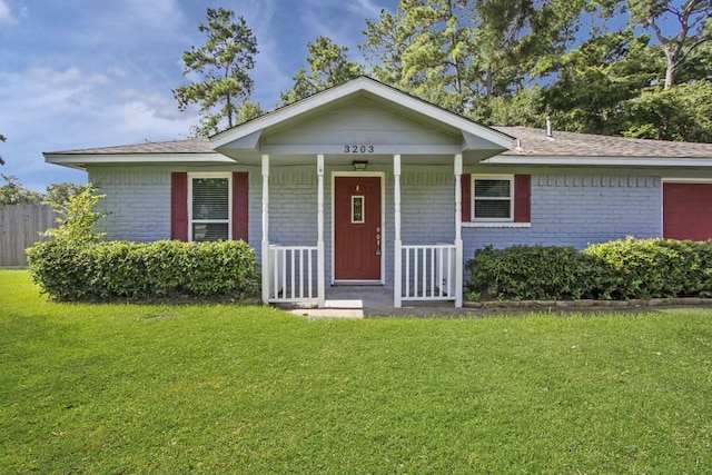 ranch-style house with a front yard and brick siding