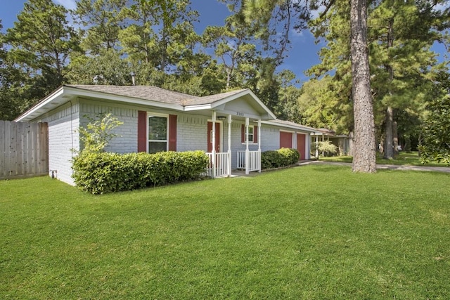 single story home featuring a garage, fence, a front lawn, and brick siding