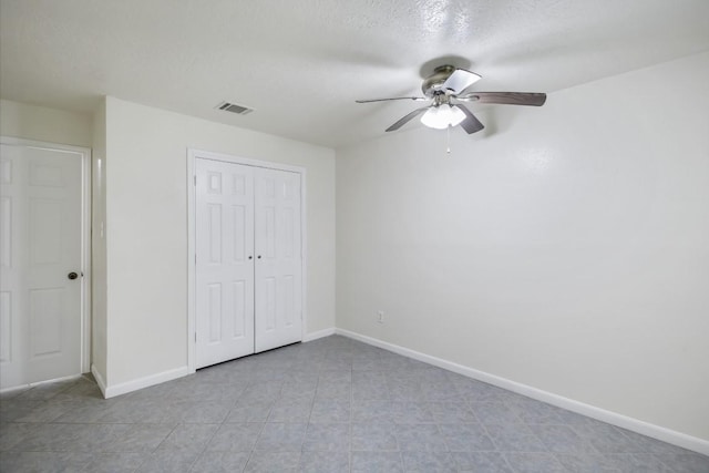 unfurnished bedroom with ceiling fan, a closet, visible vents, and baseboards