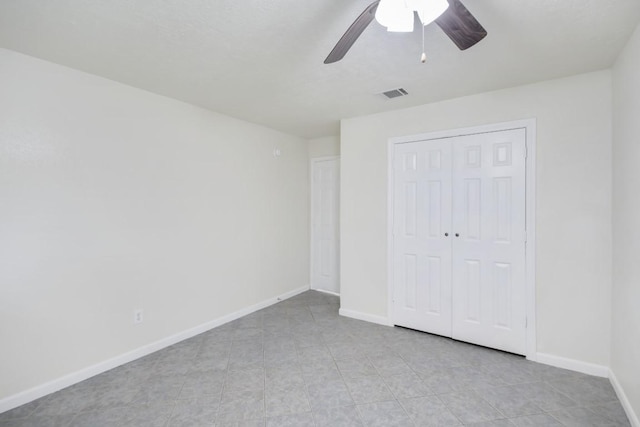 unfurnished bedroom featuring a closet, visible vents, ceiling fan, and baseboards