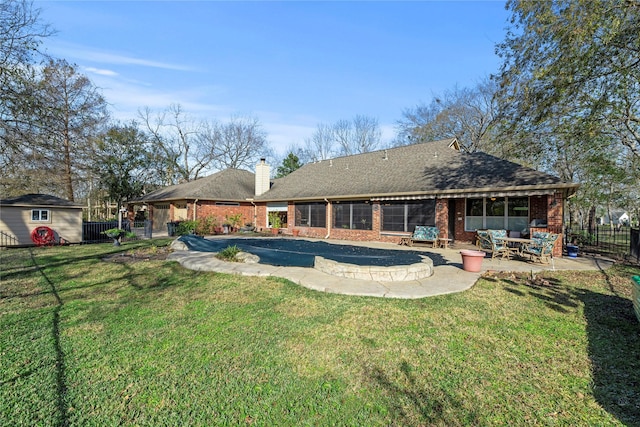 rear view of house featuring brick siding, a patio, a storage unit, a fenced backyard, and an outdoor structure