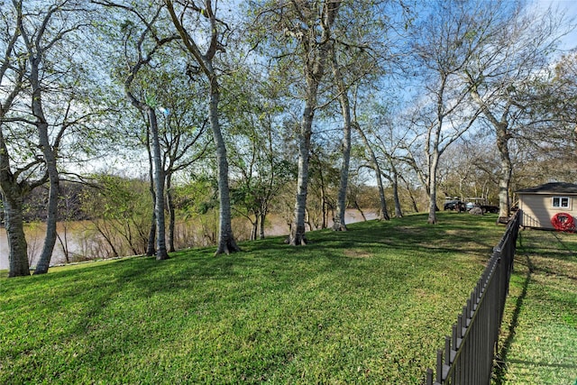 view of yard featuring a water view and fence