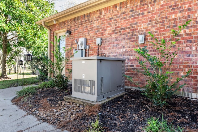 exterior details with electric meter, a power unit, and brick siding