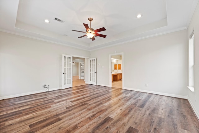 empty room with visible vents, a tray ceiling, and french doors