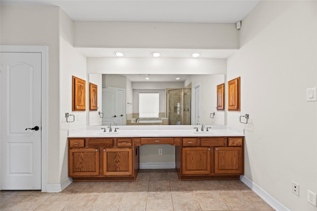 bathroom with a stall shower, a sink, baseboards, and double vanity