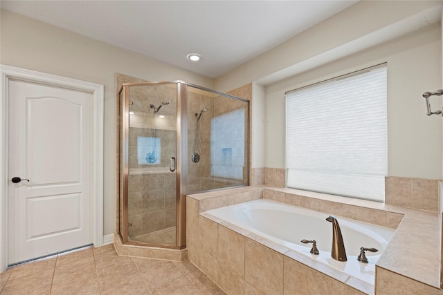 full bathroom featuring a garden tub, a shower stall, and tile patterned floors