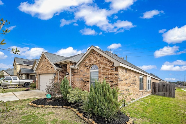 ranch-style home featuring driveway, an attached garage, fence, a front lawn, and brick siding