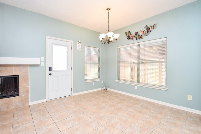 interior space with baseboards, a fireplace, and a chandelier