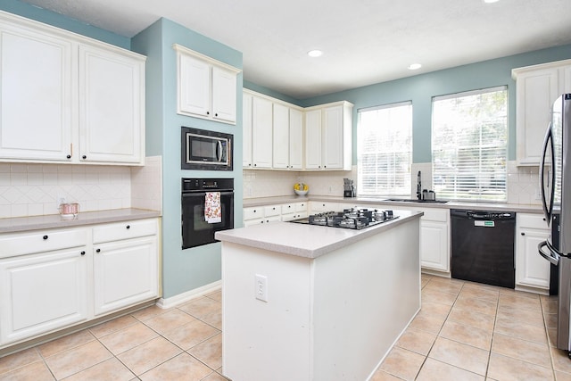 kitchen featuring black appliances, white cabinets, a sink, and light tile patterned flooring