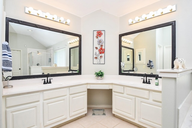 bathroom with lofted ceiling, a stall shower, a sink, and tile patterned flooring