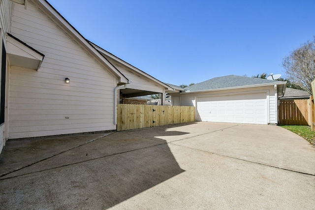 view of home's exterior featuring a garage and fence