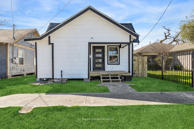 view of front of property featuring a front lawn, a porch, and fence