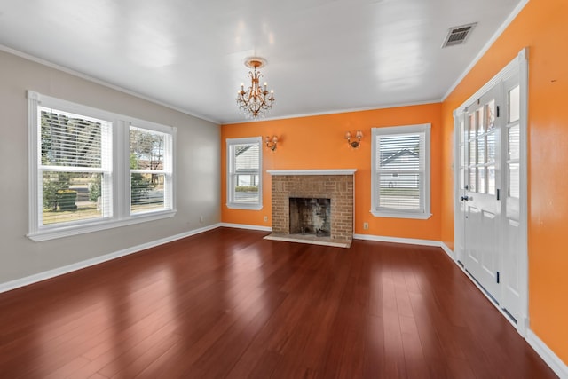 unfurnished living room with dark wood-type flooring, a fireplace, visible vents, and crown molding