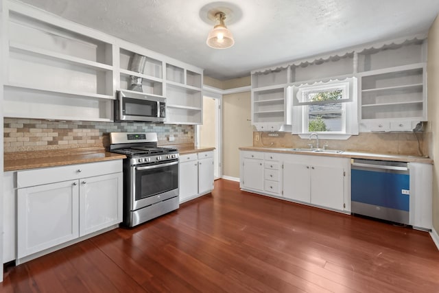 kitchen featuring stainless steel appliances, white cabinetry, a sink, and open shelves