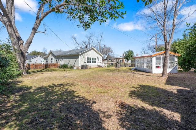 view of yard featuring central AC and fence