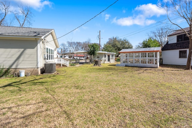 view of yard featuring central AC unit and an outdoor structure