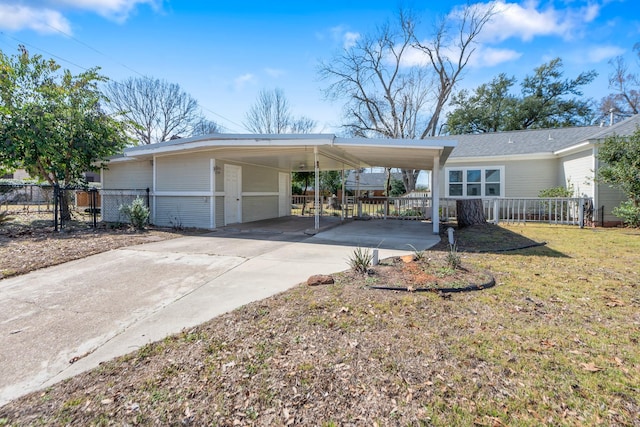 view of front of property featuring driveway, fence, an attached carport, and a front yard