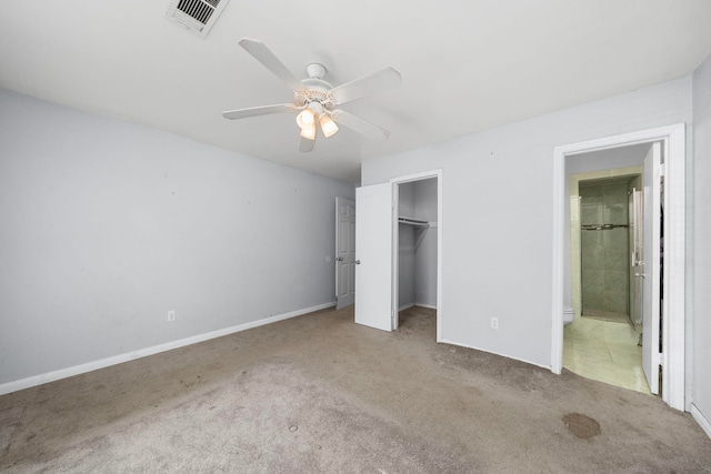 unfurnished bedroom with ensuite bathroom, carpet flooring, visible vents, a ceiling fan, and a closet