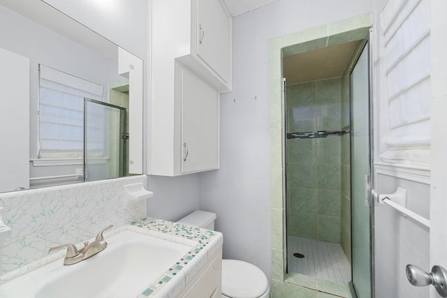 full bath with vanity, a shower stall, and toilet