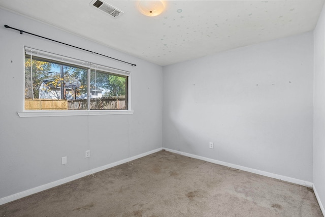 carpeted empty room with visible vents and baseboards