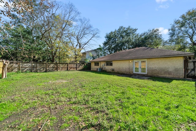 view of yard featuring french doors, cooling unit, and a fenced backyard