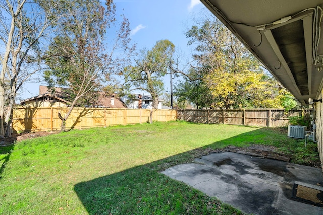 view of yard featuring central air condition unit, a fenced backyard, and a patio