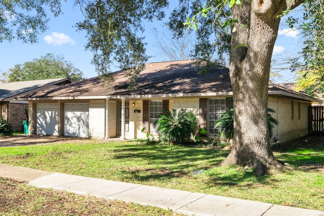 view of front of property with driveway, a front lawn, an attached garage, and brick siding