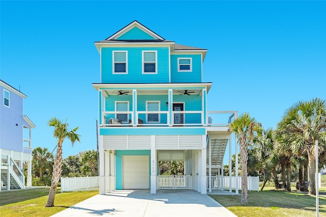 beach home featuring fence, a ceiling fan, stairs, concrete driveway, and a carport