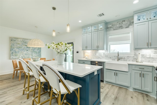 kitchen featuring dishwasher, visible vents, pendant lighting, and light countertops