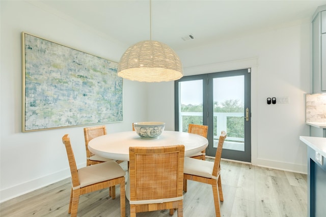 dining space with light wood-style floors, visible vents, and baseboards