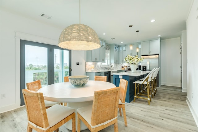 dining room featuring baseboards, light wood finished floors, visible vents, and recessed lighting