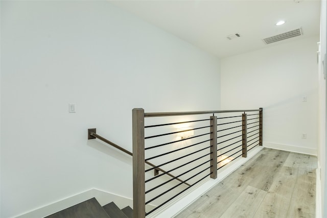 staircase with recessed lighting, wood finished floors, visible vents, and baseboards