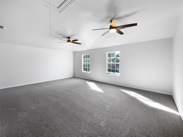 carpeted spare room with attic access, visible vents, ceiling fan, and baseboards