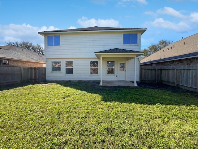 rear view of property with a yard, a patio, and a fenced backyard