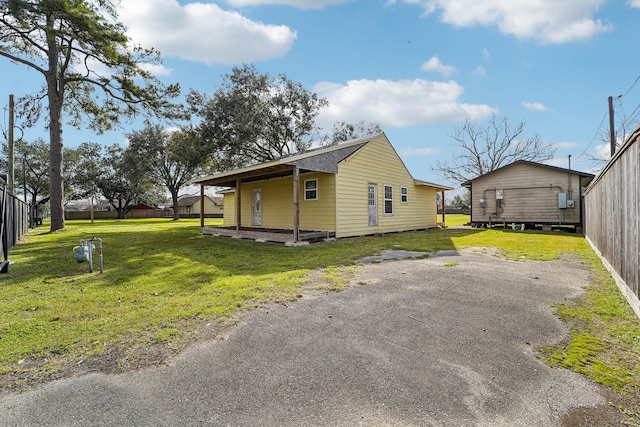 view of side of property featuring fence and a lawn