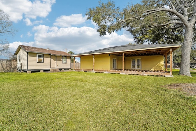 back of house featuring entry steps and a lawn