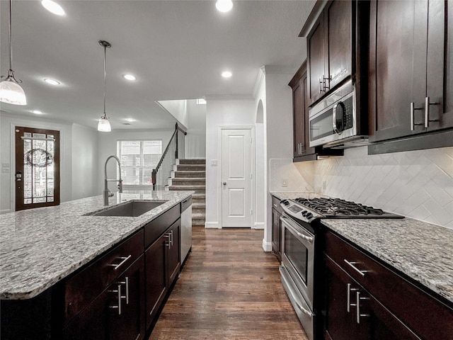 717 Via Lago, Webster, TX 77598 - kitchen with appliances with stainless steel finishes, a sink, recessed lighting, light stone counters, and ornamental molding
