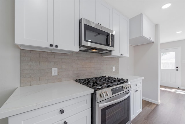 14415 Bryce Meadow Ln, Houston, TX 77047 - kitchen featuring appliances with stainless steel finishes, white cabinets, and light wood-type flooring