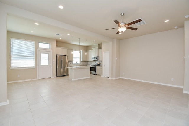 unfurnished living room featuring a ceiling fan, recessed lighting, visible vents, and baseboards