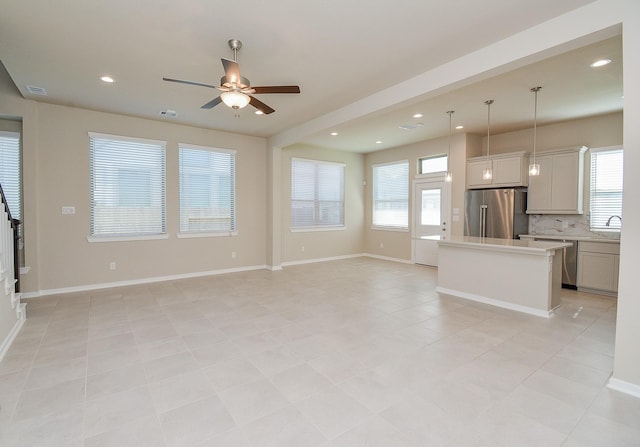 unfurnished living room featuring baseboards, visible vents, ceiling fan, and recessed lighting