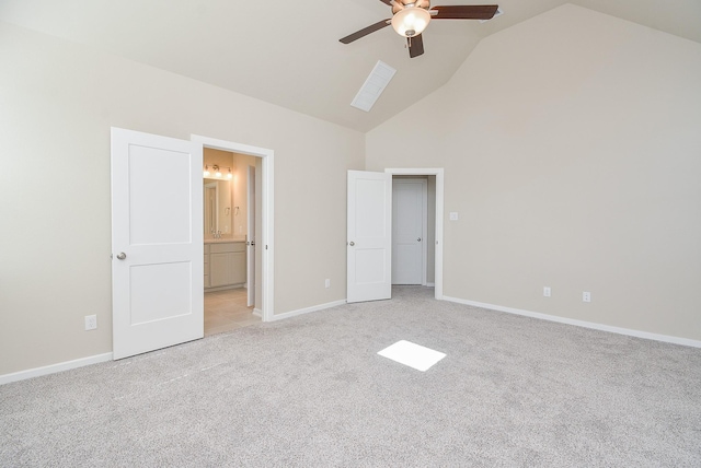 unfurnished bedroom with high vaulted ceiling, connected bathroom, light carpet, a ceiling fan, and baseboards