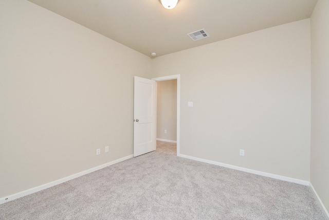 empty room featuring carpet flooring, visible vents, and baseboards