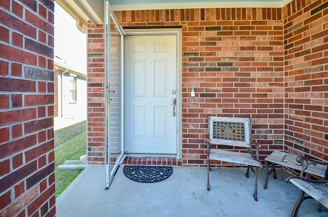doorway to property featuring brick siding