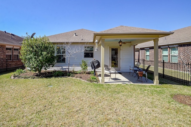 rear view of house with a yard, a ceiling fan, a patio, and fence