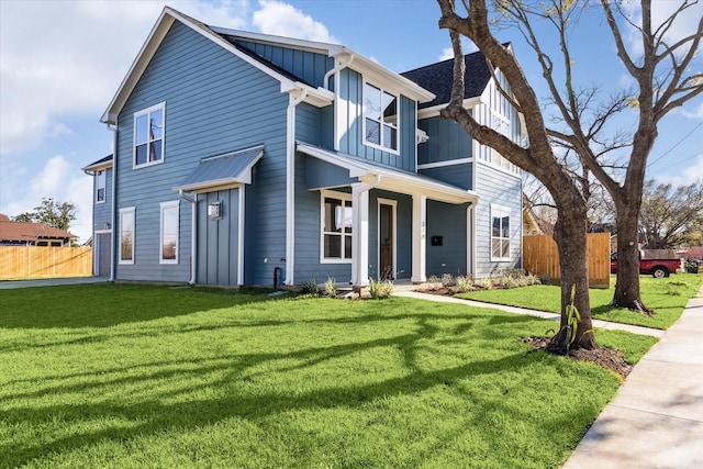 view of front of house with fence, a front lawn, and board and batten siding